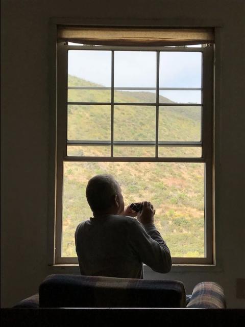 viendo con biniculares el horizonte desde la ventana